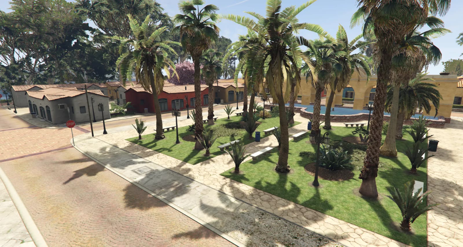 The palm-lined square at the centre of Coral Island’s new town, with benches, lamp posts and a fountain beside low terracotta-roofed buildings